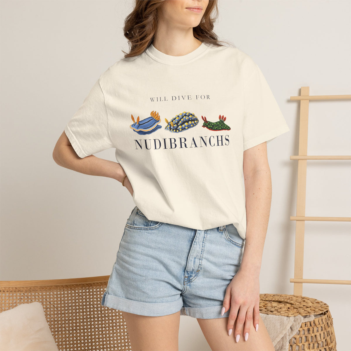 Ivory Will Dive for Nudibranchs tee on a model with a hand on her hip, denim shorts