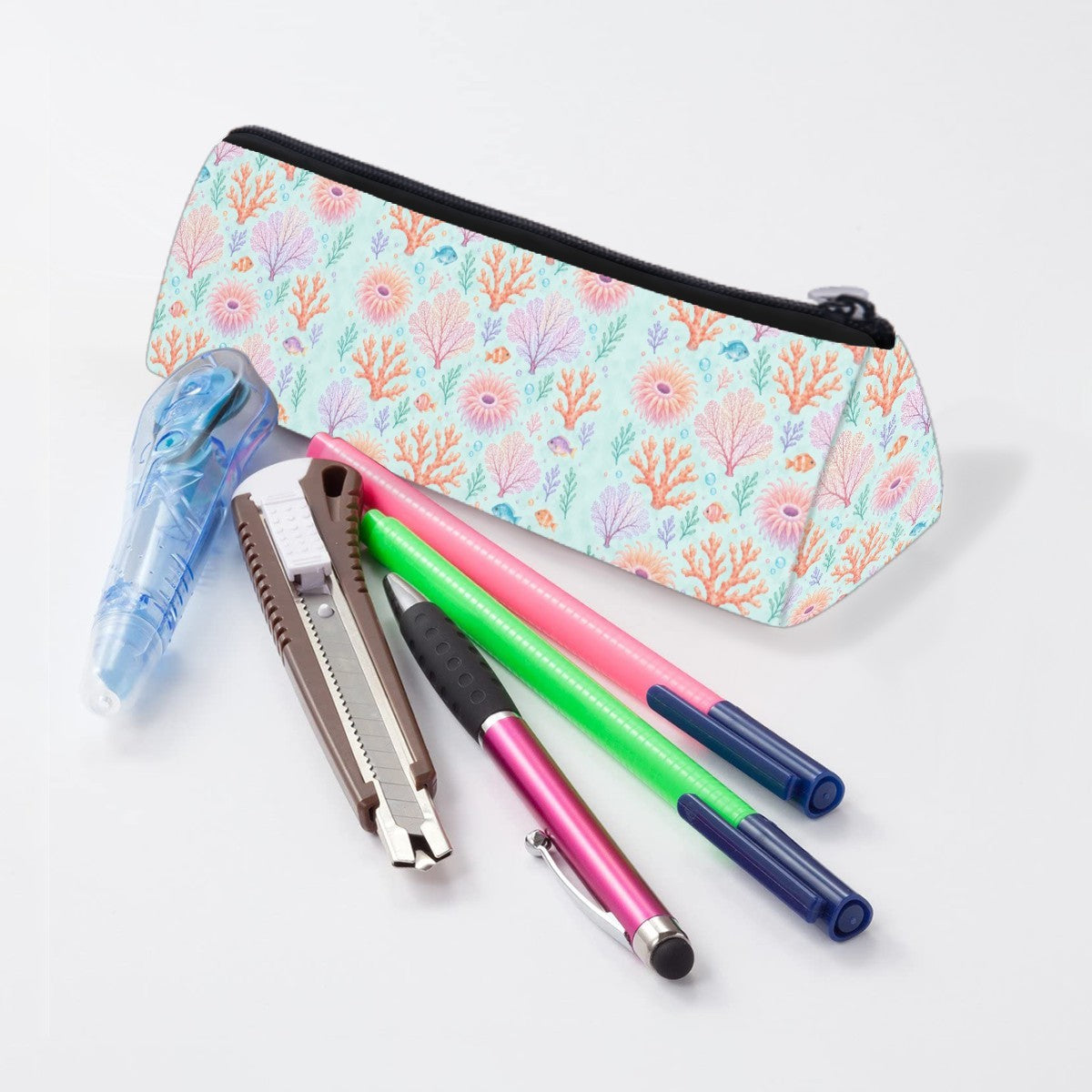 Coral reef pencil case lying beside pens and markers