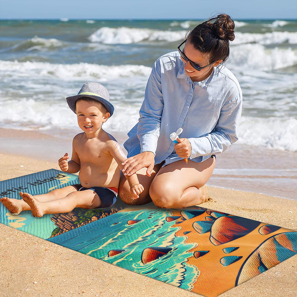 Family on the sand with the rocky cove beach towel laid out
