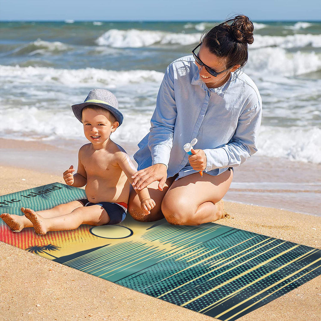 Family on the sand with the sunset beach towel laid out