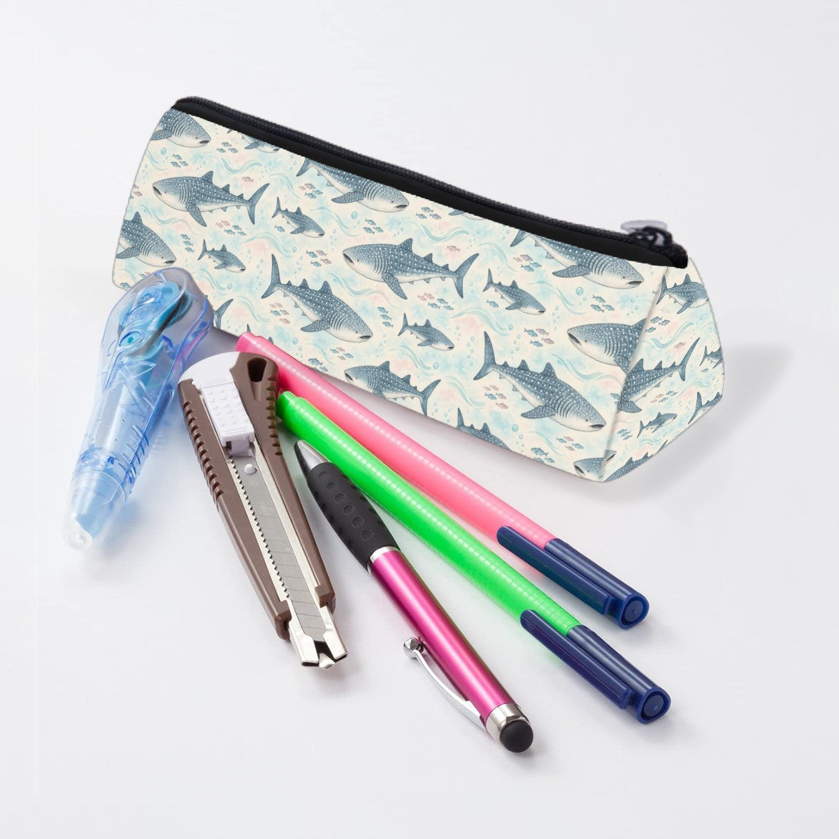 Whale shark pencil case lying beside pens and markers