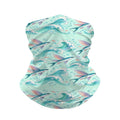 Neck gaiter and diving headband with pink and coral flying fish above teal and white breaking waves on a mint background