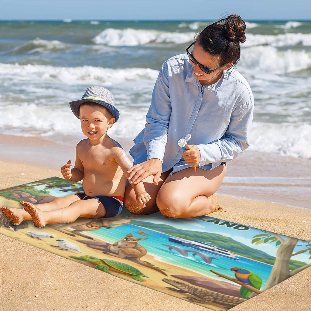 Family on the sand with the Magnetic Island wildlife scene beach towel laid out