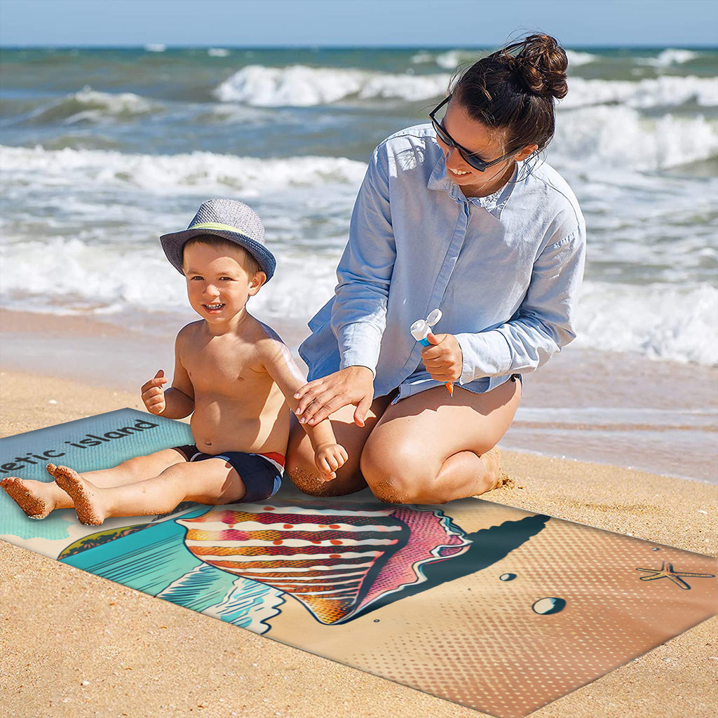 Family on the sand with the shell beach towel laid out