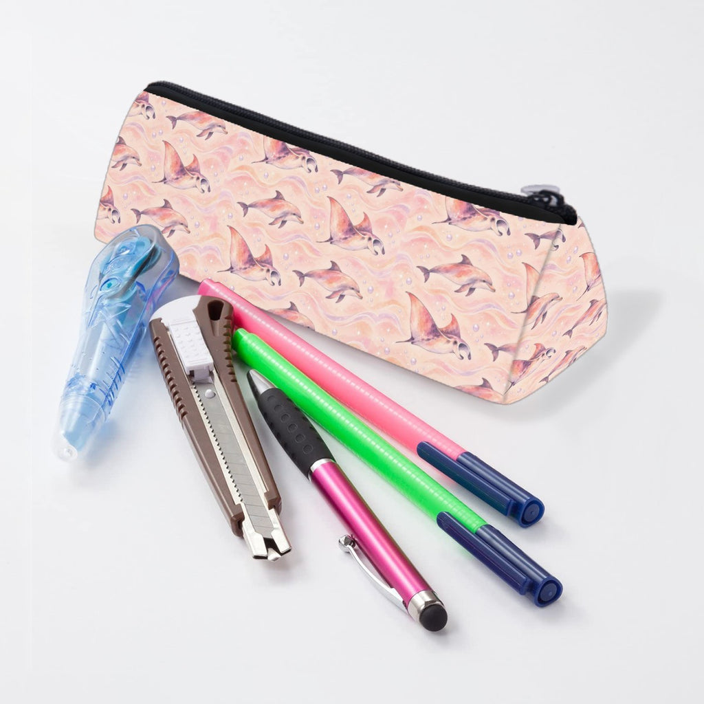 Dolphin and ray pencil case lying beside pens and markers