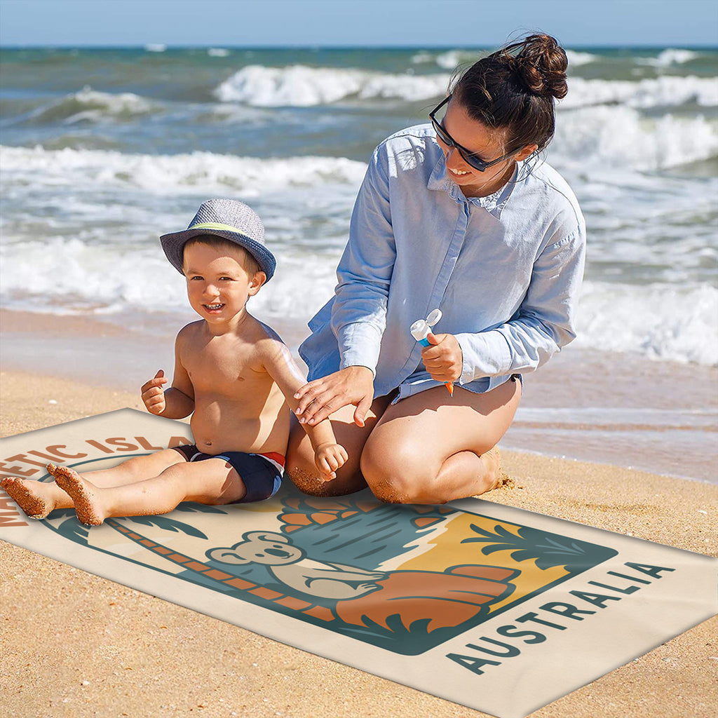 Family on the sand with the retro Magnetic Island koala badge beach towel laid out