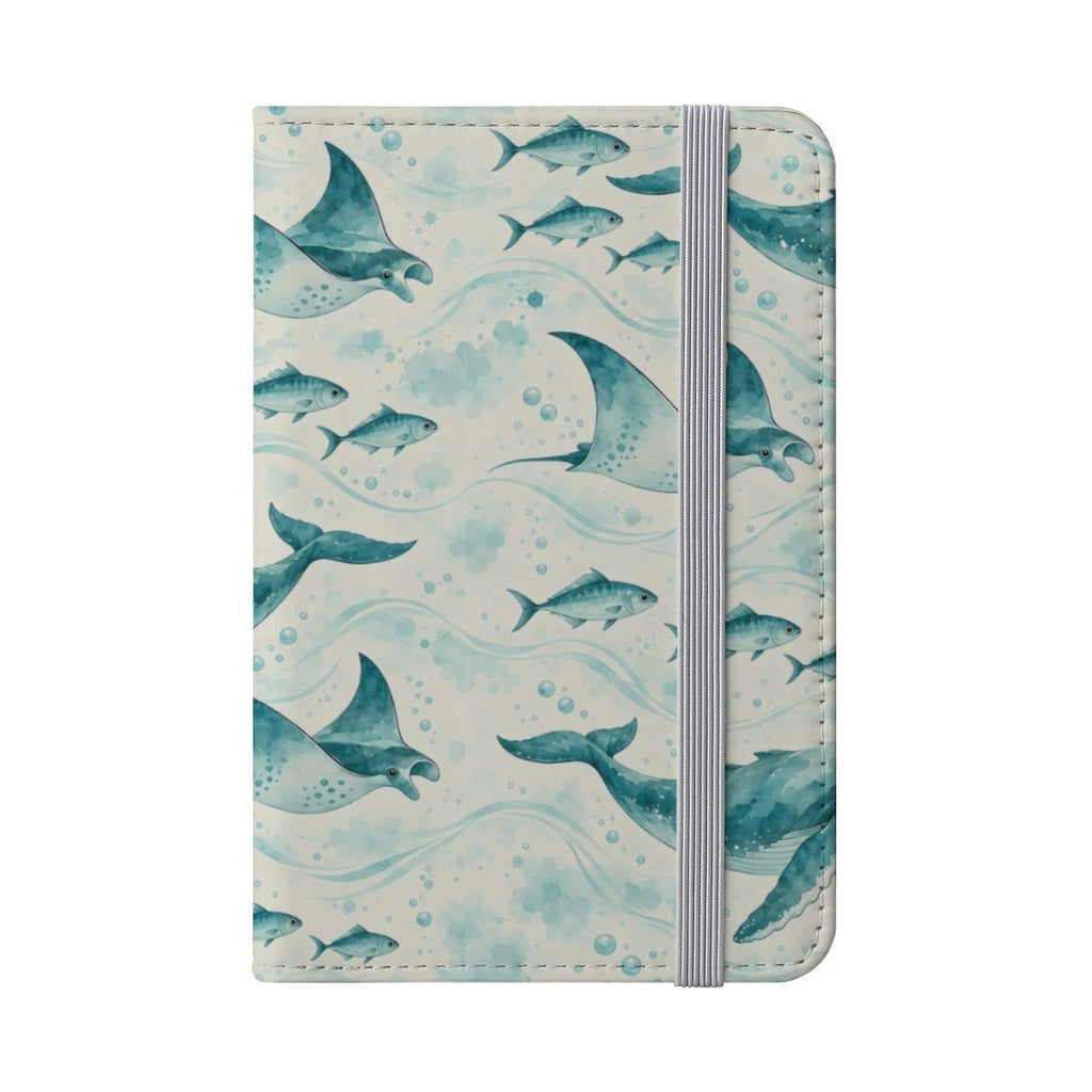 Teal whale, ray and fish pattern passport cover with a grey elastic band, front view on white