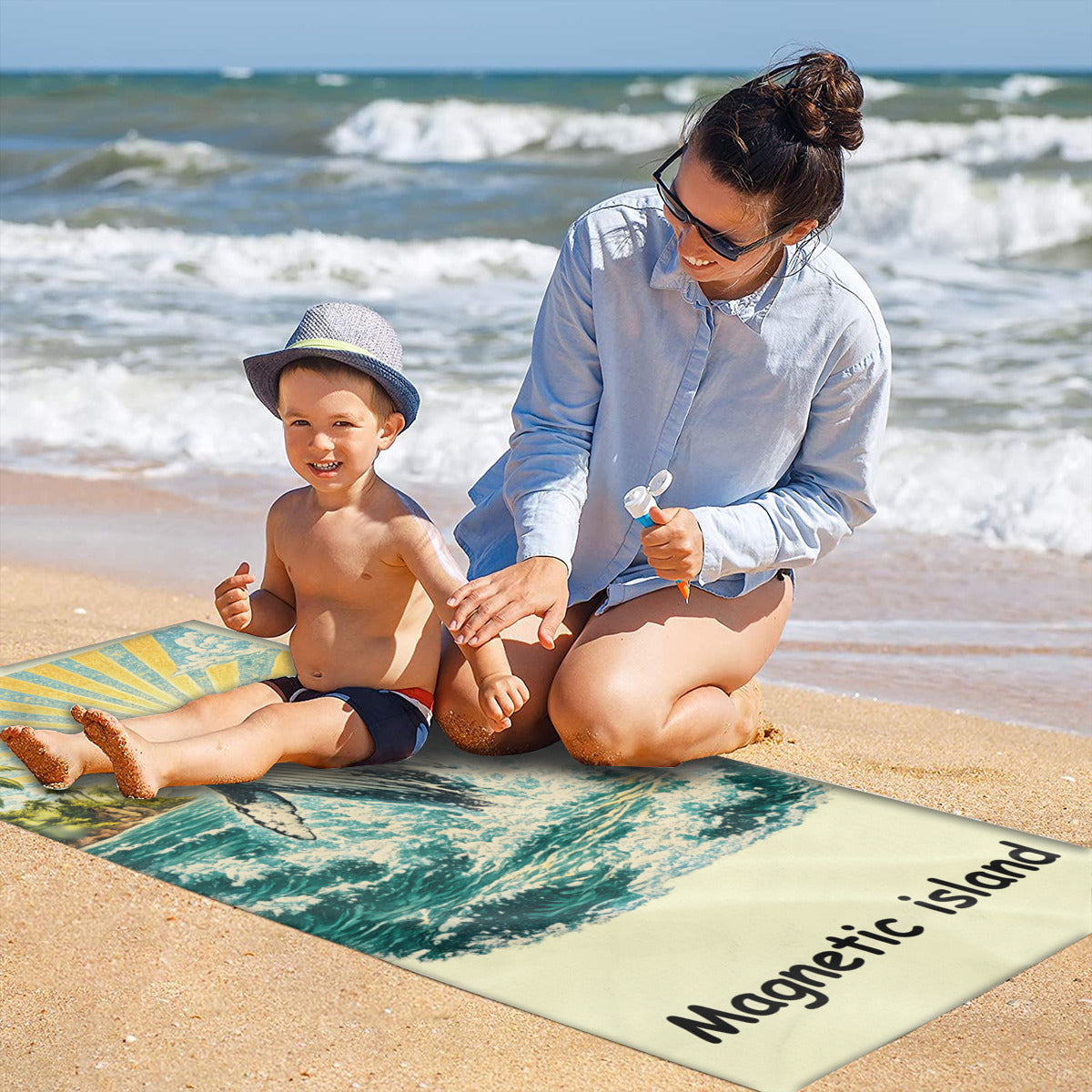 Family on the sand with the humpback whale beach towel laid out