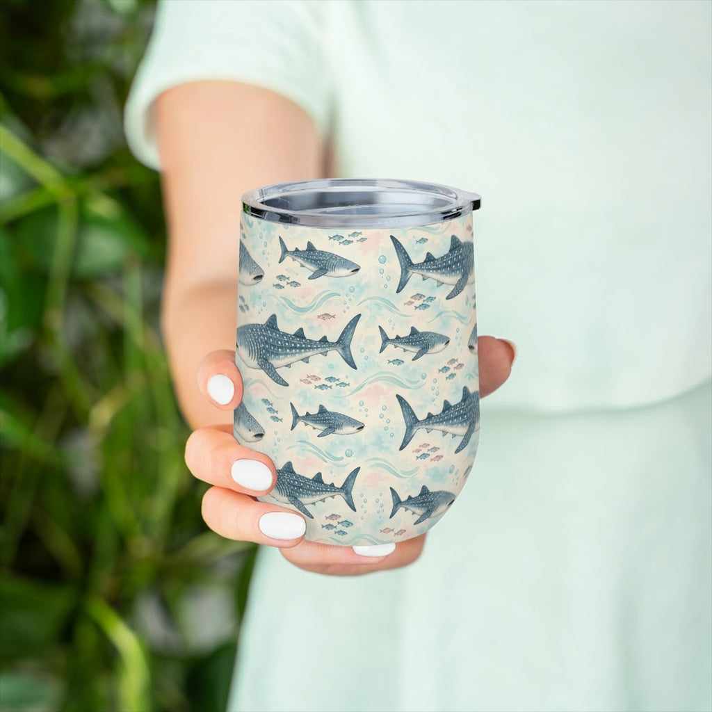 Hand holding the whale shark pattern tumbler in front of green leaves, with a pale green top behind
