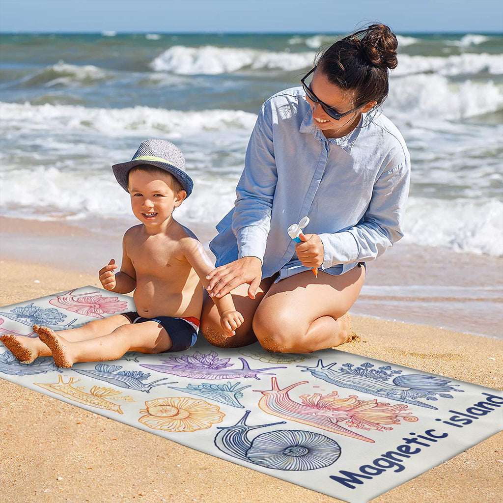 Family on the sand with the nudibranch beach towel laid out