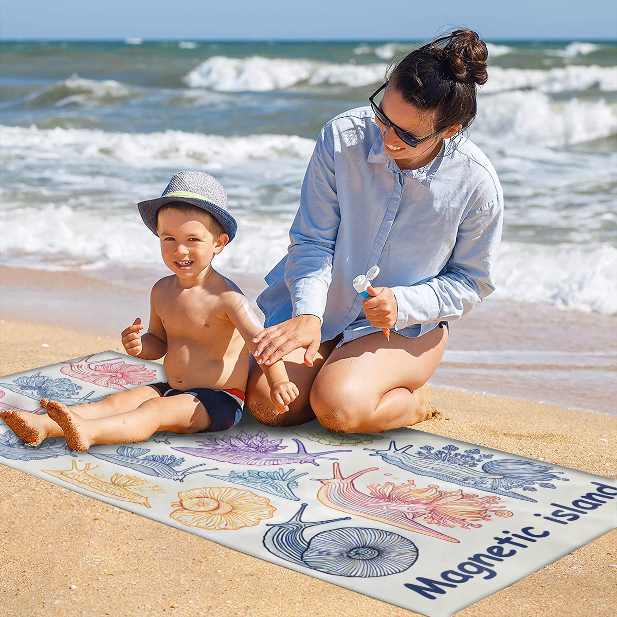 Family on the sand with the nudibranch beach towel laid out