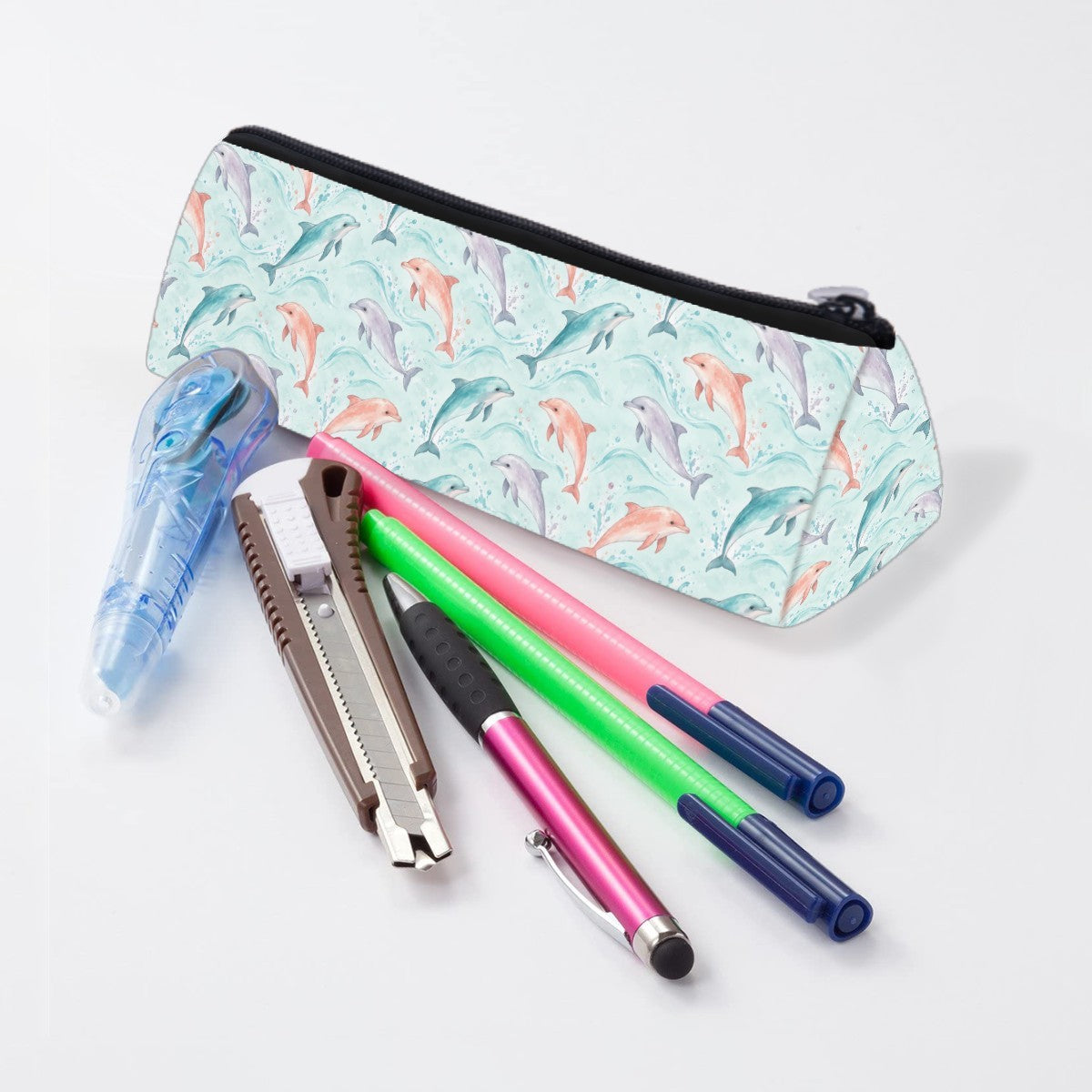 Dolphin pencil case lying beside pens and markers
