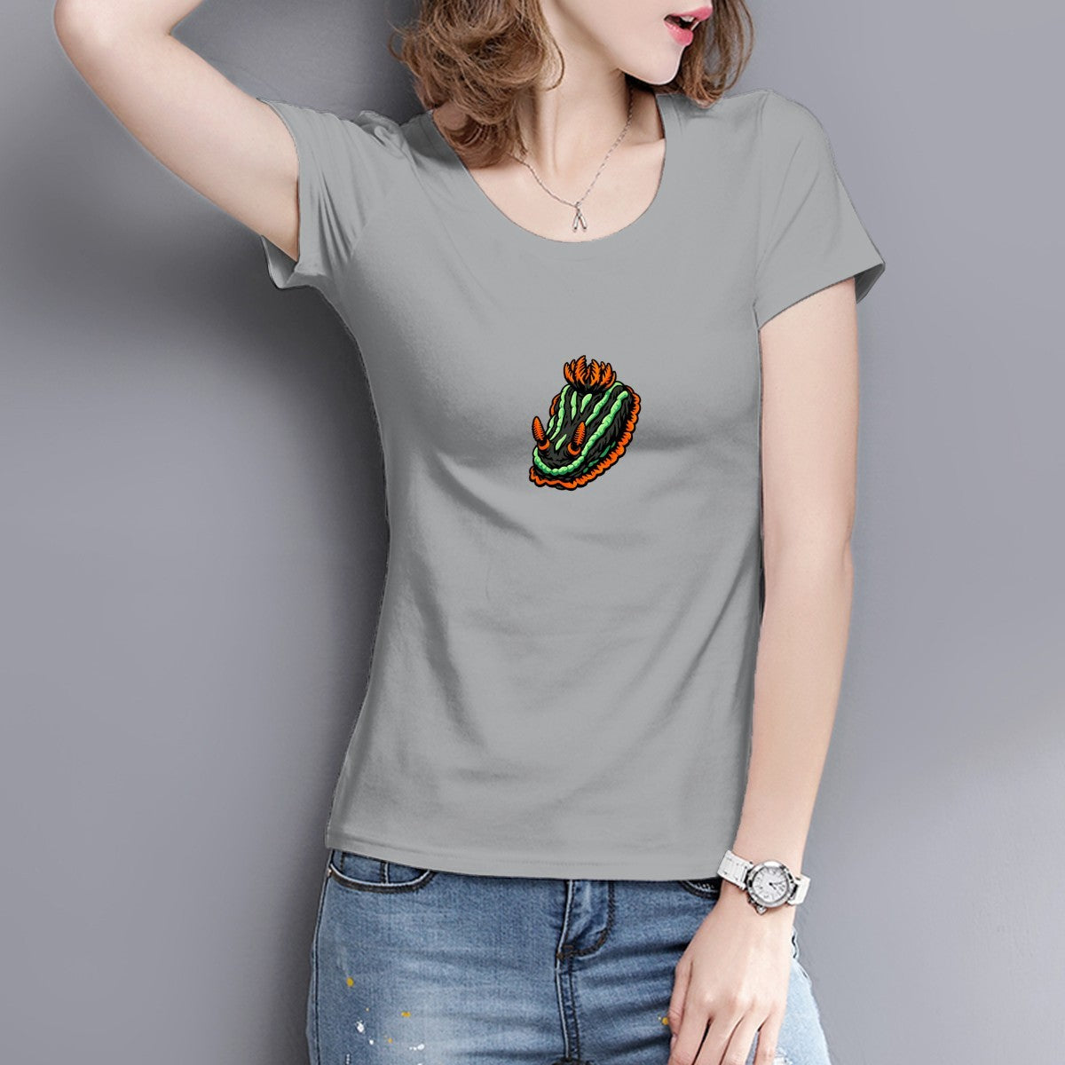 Woman in a silver grey Nembrotha nudibranch tee against a grey wall