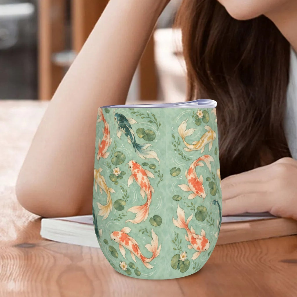 Koi tumbler standing on a wooden table beside a woman resting her arm