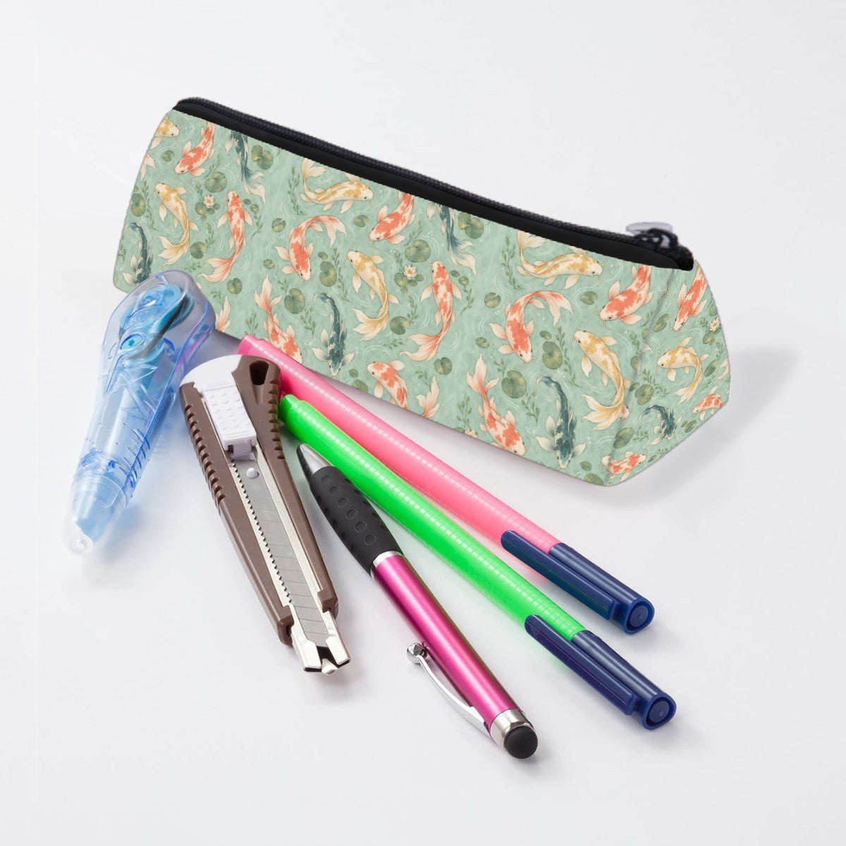Koi pencil case lying beside pens and markers