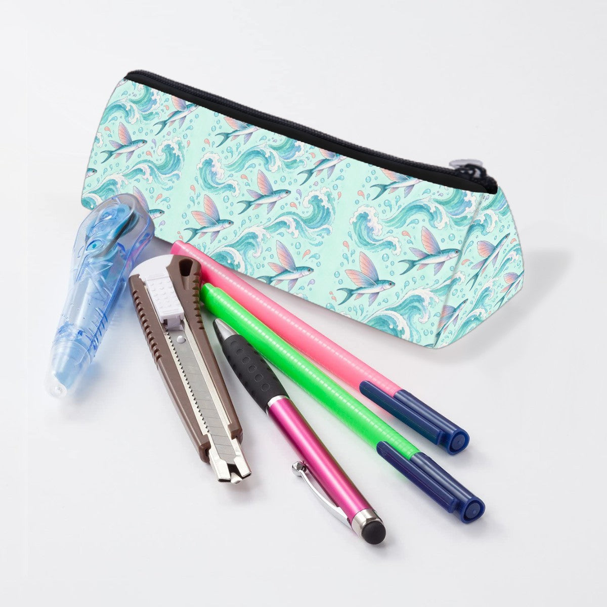 Flying fish pencil case lying beside pens and markers