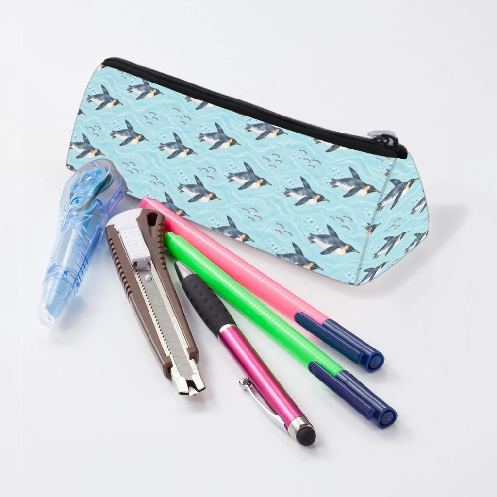 Penguin pencil case lying beside pens and markers