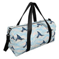 Slate blue spotted eagle ray pattern duffle bag with two black handles and a shoulder strap, three-quarter view