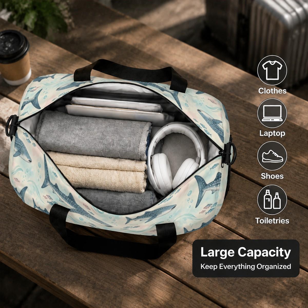 Open whale shark duffle bag packed with folded clothes and headphones, labelled Large Capacity